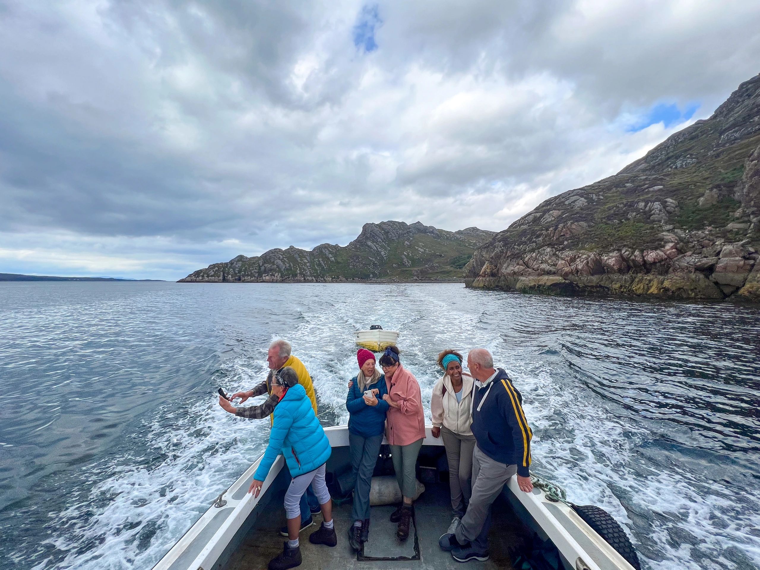 Group of friends on a tour boat enjoying the sea views